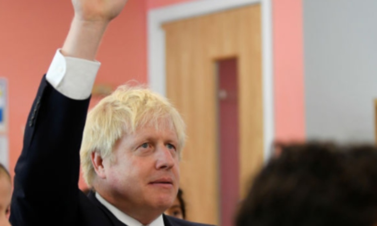 Il premier inglese, Johnson, alza la mano in classe