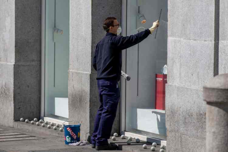 Negoziante che pulisce vetrina - Getty images