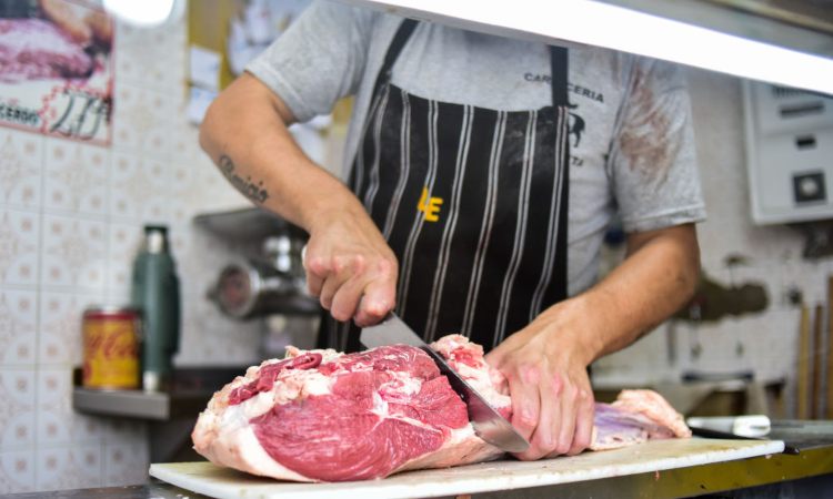 Macellaio taglia carne con coltello