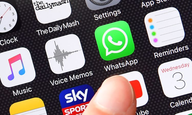 Il logo di Whatsapp e un dito sul display