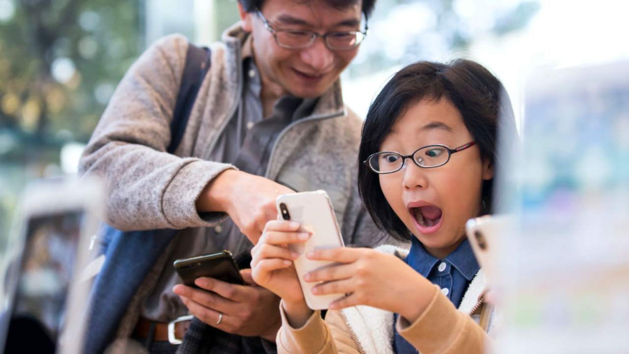 Due ragazzi guardano il display di un cellulare