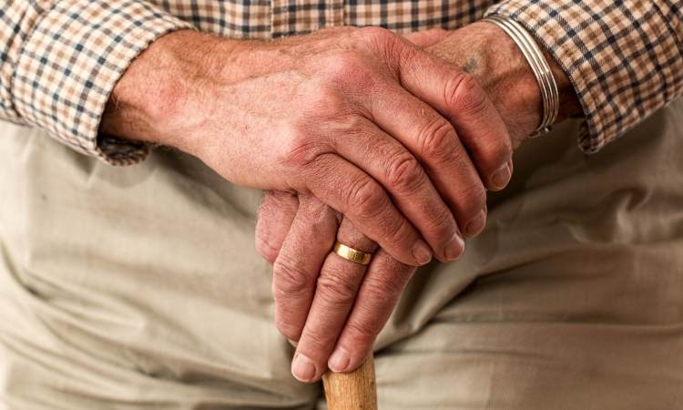 anziano signore si regge sul bastone 