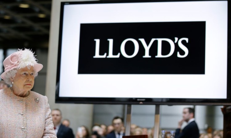 La regina Elisabetta vicino alla scritta della banca Lloyds