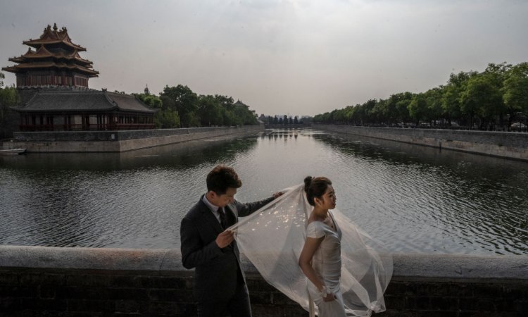 Due sposini si lasciano fotografare sulle rive di un fiume