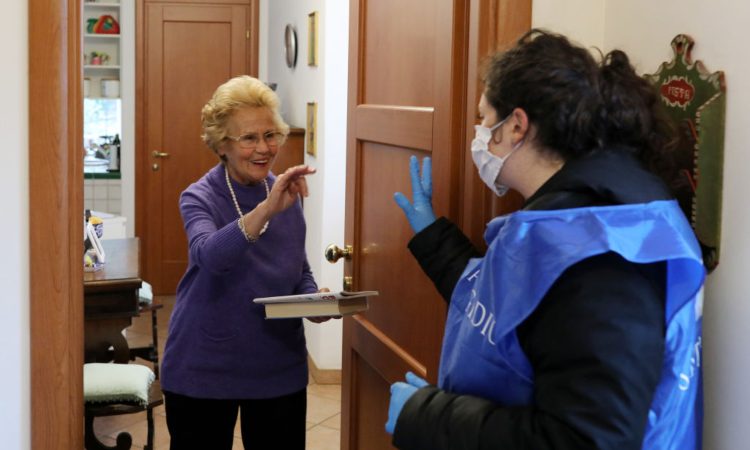 Una signora anziana sulla porta di casa