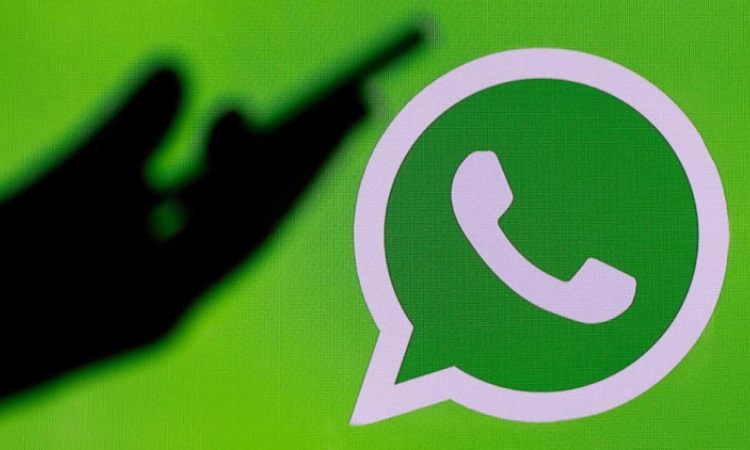 Il logo di Whatsapp e una mano in penombra