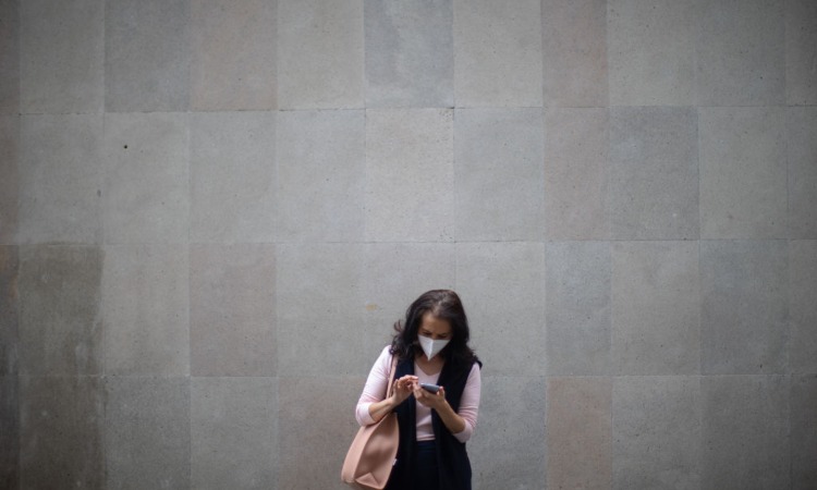 Una donna intenta a guardare lo schermo di un cellulare