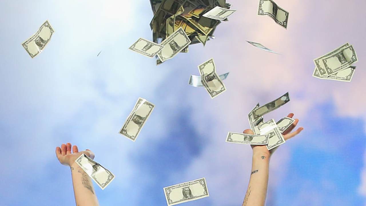 Due mani lanciano dei soldi in aria