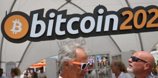 Una scritta inerente i Bitcoin e alcune persone nelle vicinanze