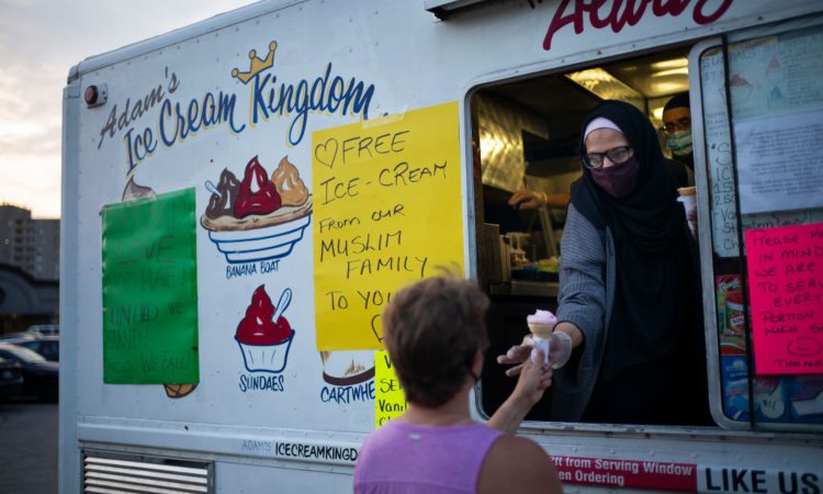 Un rivenditore passa un gelato ad un cliente