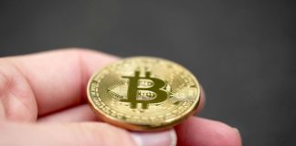 Una mano tiene una Bitcoin dorata