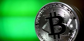 Una Bitcoin argentata con uno sfondo verde