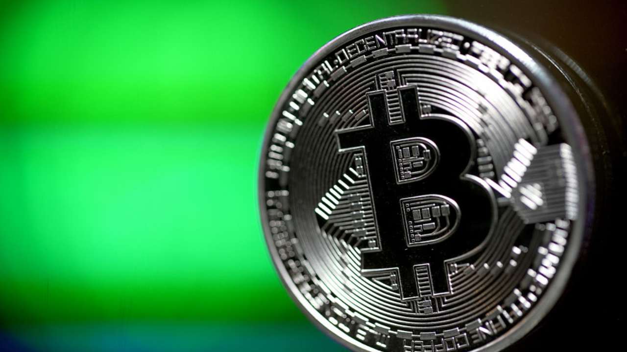 Una Bitcoin argentata con uno sfondo verde