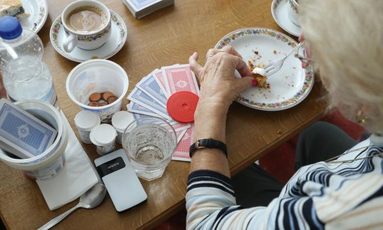 Una donna mentre mangia con il piatto sul tavolo