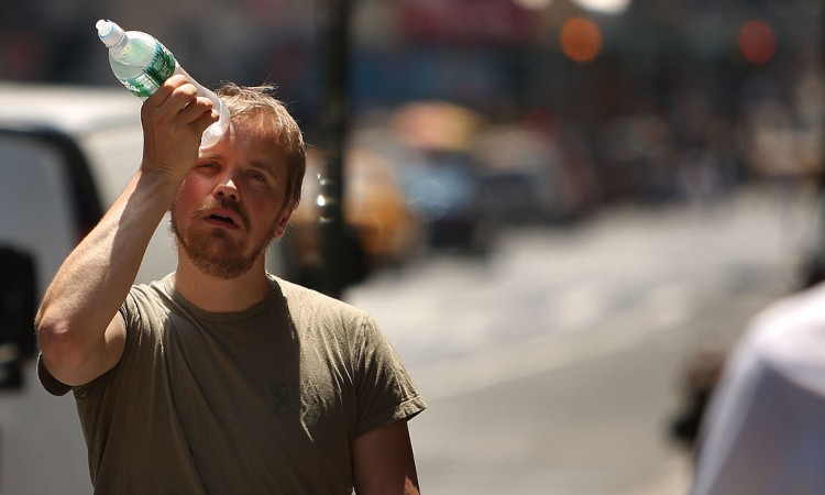 Un ragazzo con una bottiglia d'acqua sulla testa